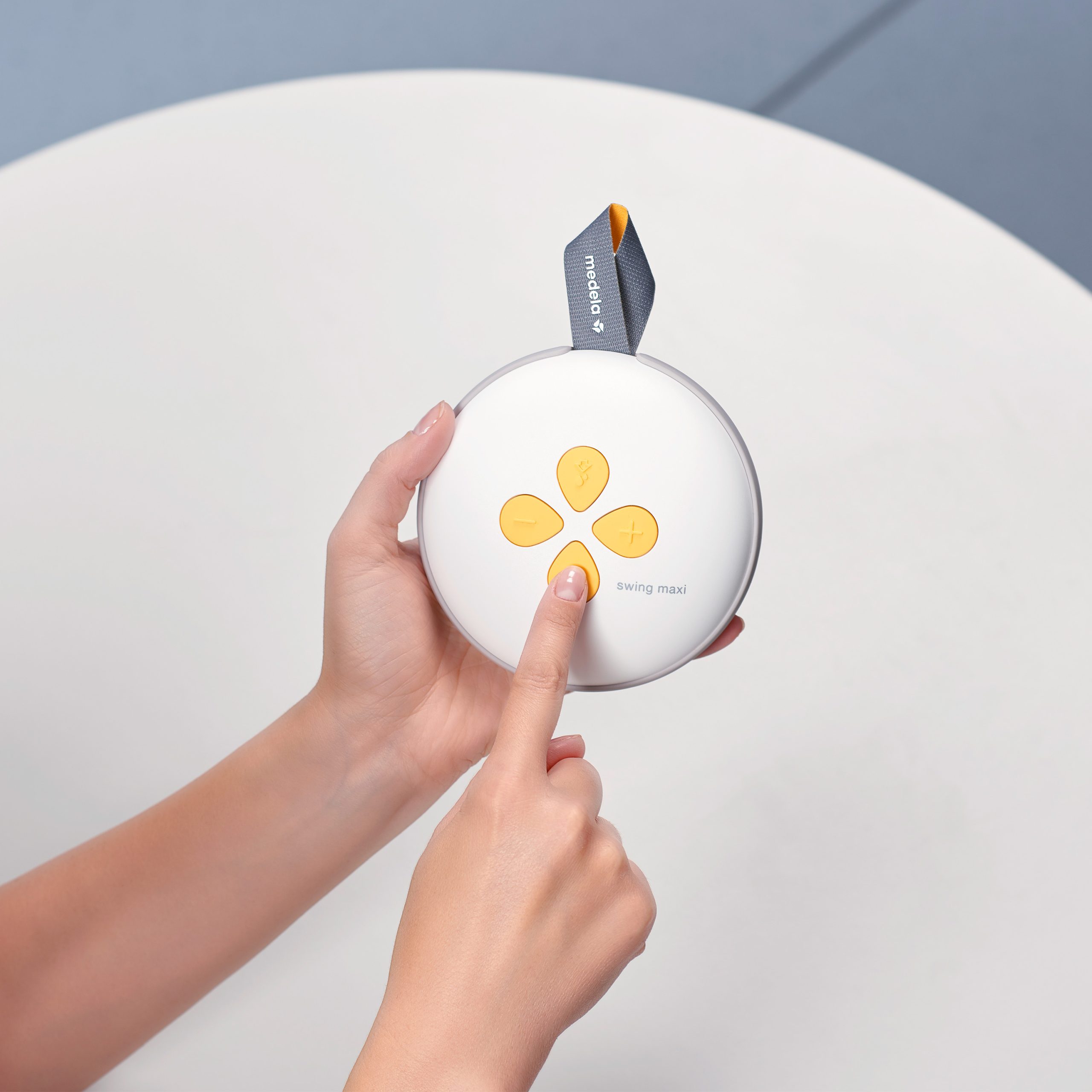 Woman pushing buttons on the Medela Wing Maxi Double Electric Breast Pump